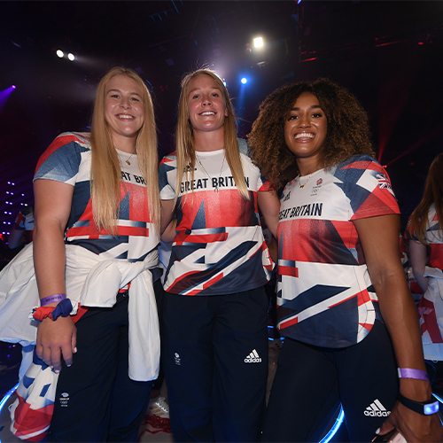 Three women in British team shirts standing together at the National Lottery homecoming event at AO Arena.